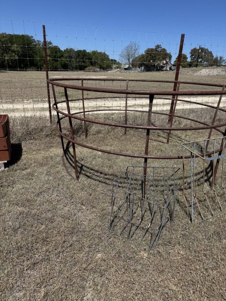 Rusty metal livestock pen on dry grass at Mike Luckey Estate Auction.