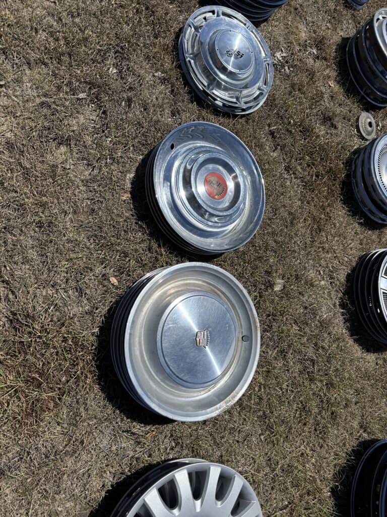 Vintage car hubcaps displayed outdoors at Garrett Realty & Auction.
