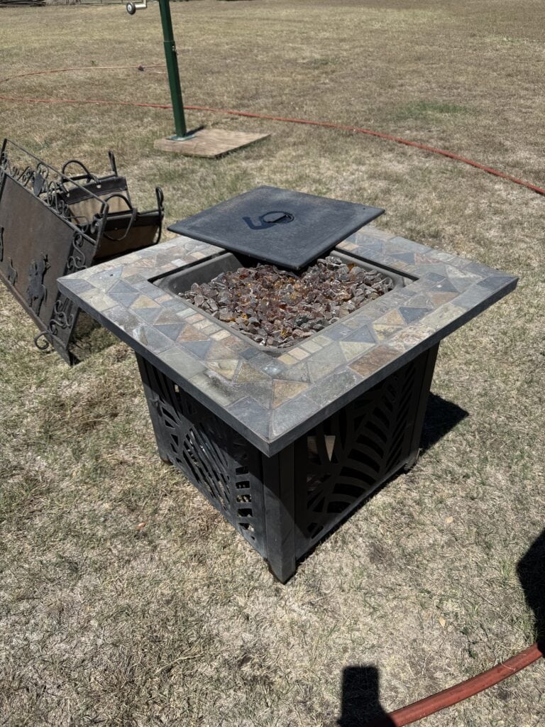 Outdoor fire pit with stone and metal design, perfect for backyard gatherings.