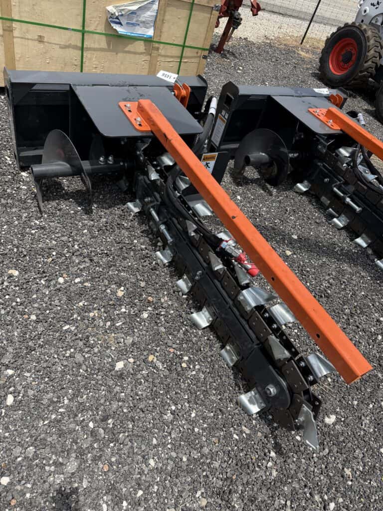 Two landscape rakes with orange bars and black frames at auction site.