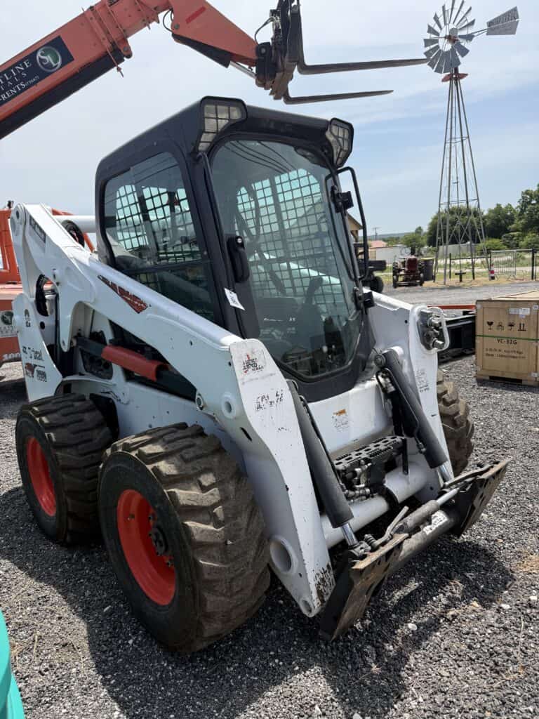 Used Bobcat skid-steer loader with enclosed cab at equipment auction.