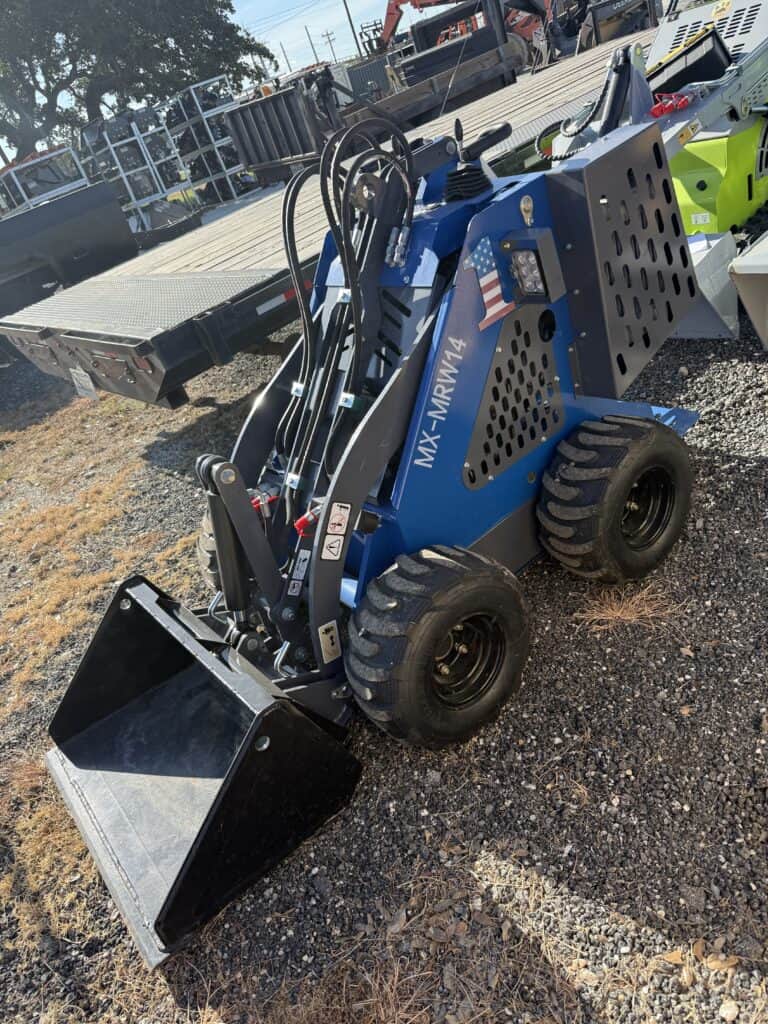 Blue mini skid steer loader with bucket attachment at equipment auction.