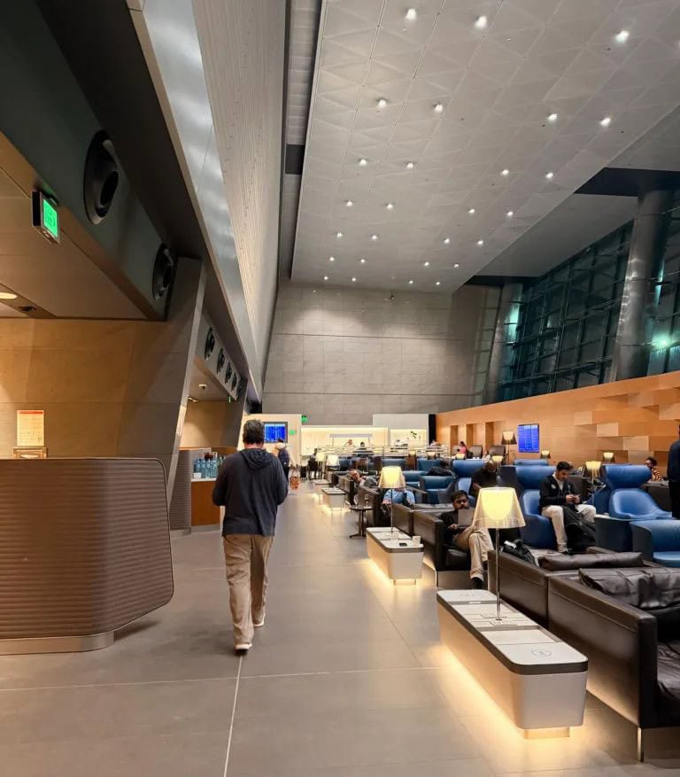 Elegant airport lounge interior with comfortable seating and travelers waiting.
