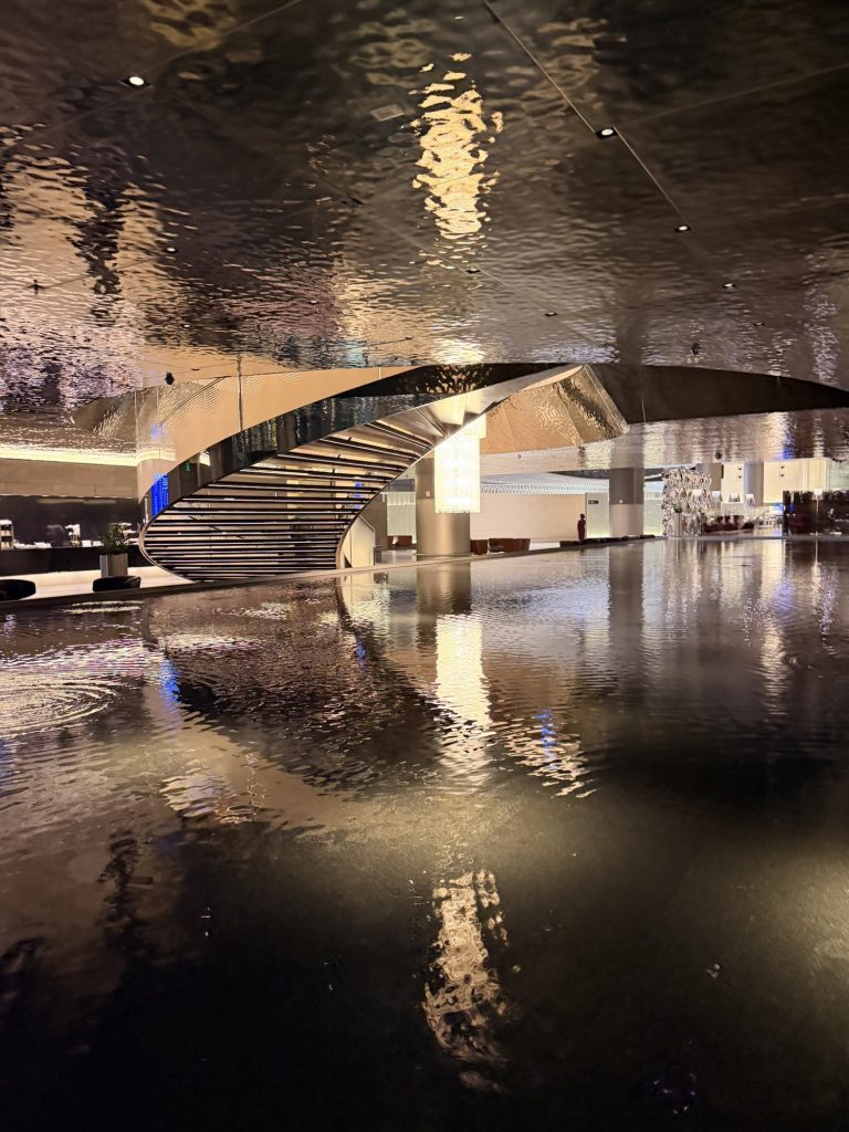 Indoor architectural staircase with reflection in water, showcasing contemporary design.