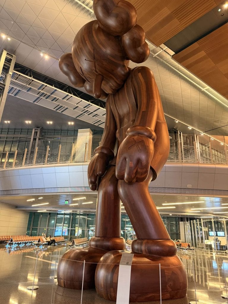 Wooden Mickey Mouse sculpture in an airport terminal.