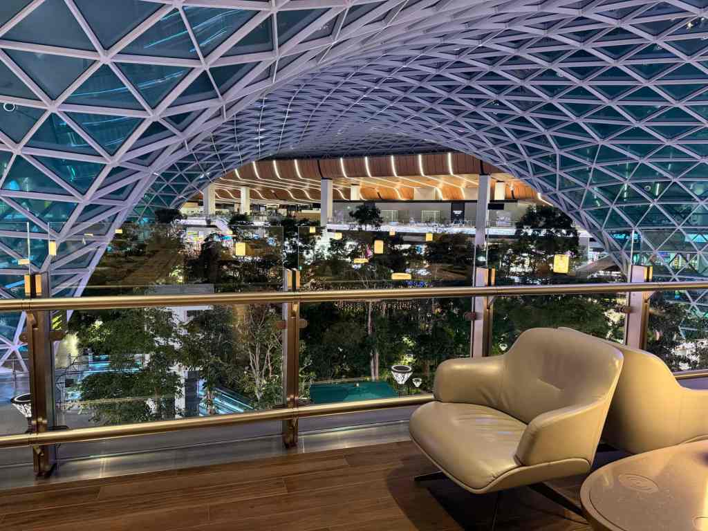 Luxury airport lounge with modern architecture and city view at night.