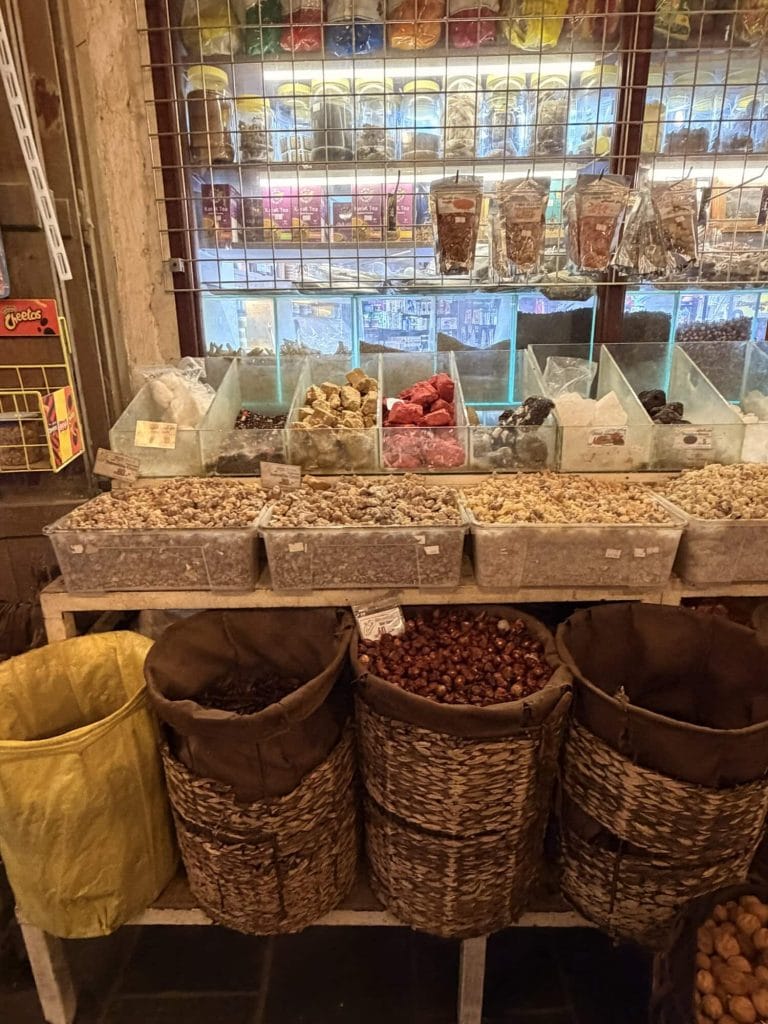 Colorful dried fruits and nuts in bins and bags for sale.