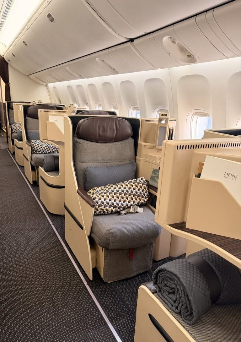 Airplane cabin interior with luxurious seats and amenities.