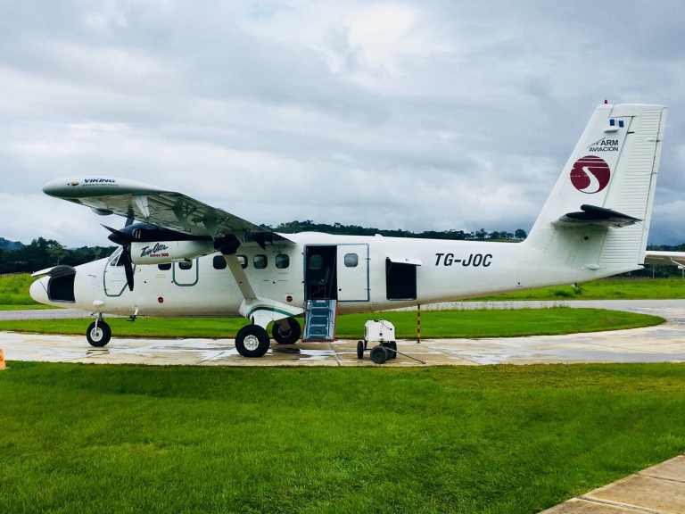 Small aircraft parked on the runway with open door, ready for travel.