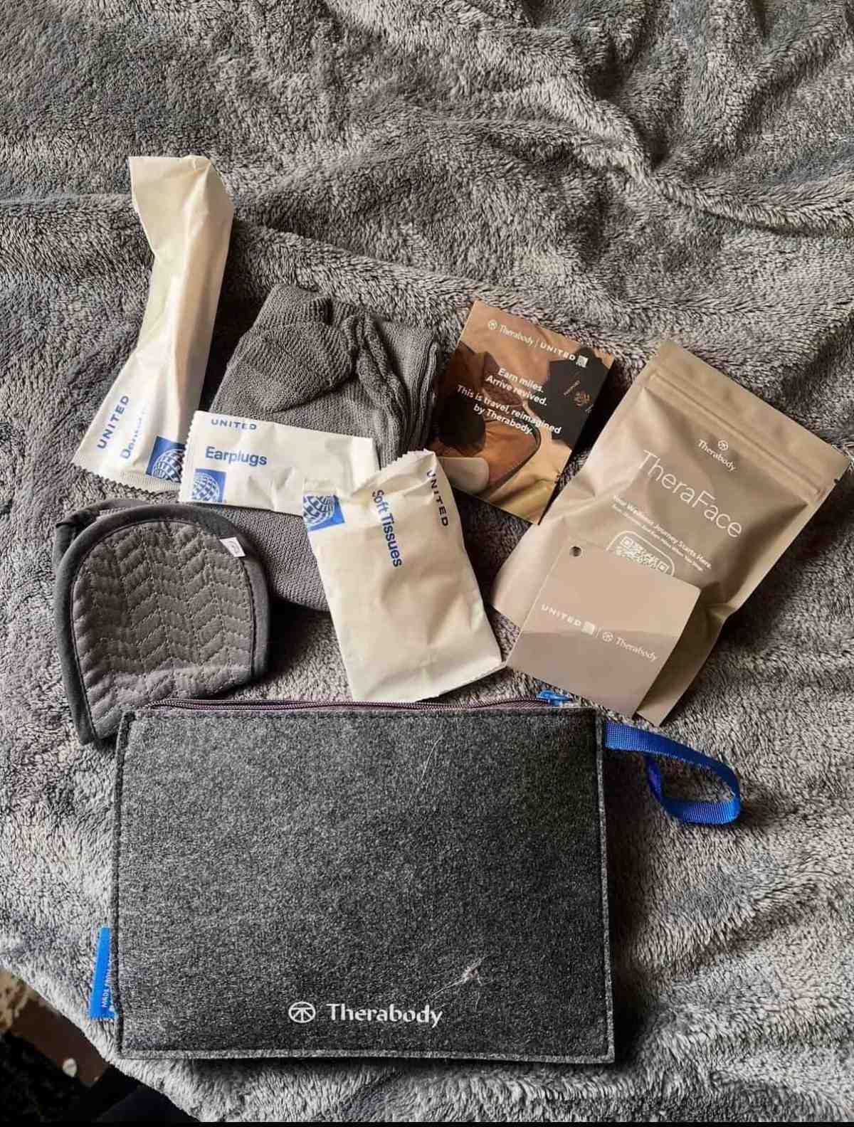 Portable travel wellness kit with Therabody massage tools and accessories for relaxation.