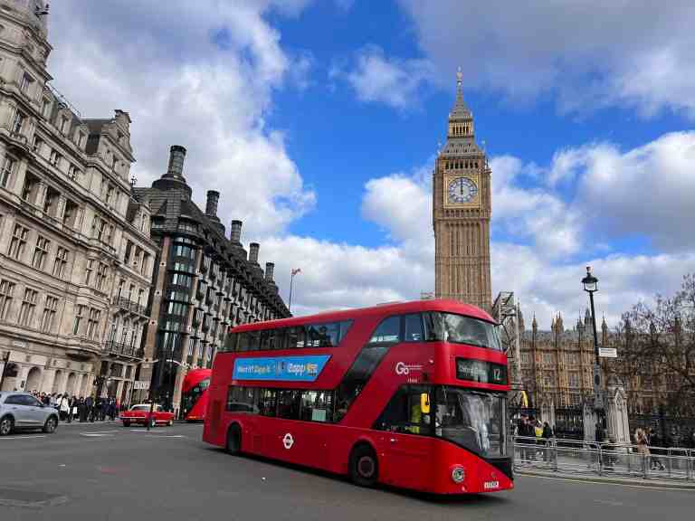 London double-decker bus with Big Ben in background, iconic UK sightseeing scene.