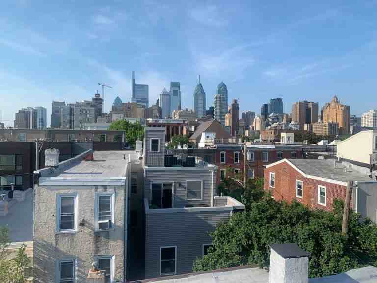 Philadelphia skyline with residential neighborhood and blue sky.