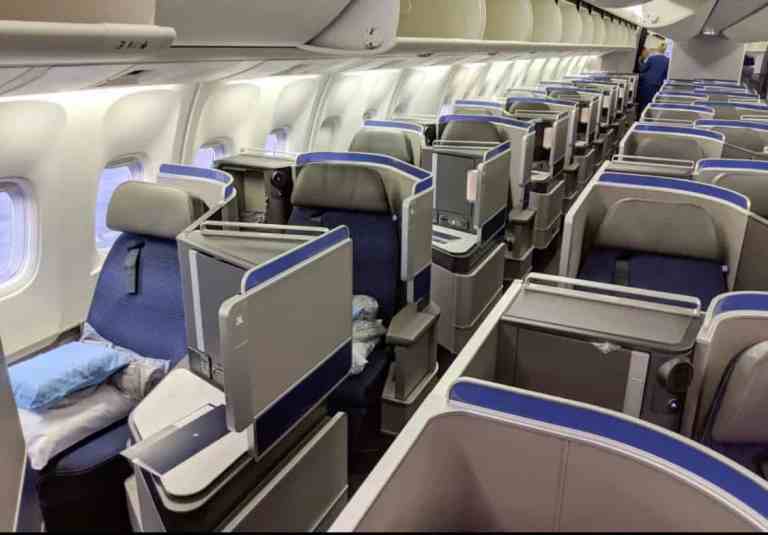 Luxury airplane cabin with spacious seats and personal entertainment screens.