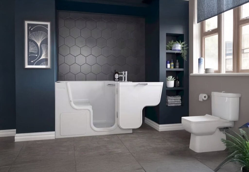 Walk in bath Rimini (Tranquility. Side door wide open showing capacity size and built in seat. Lavish accessible bathroom with deep dark navy blue walls and complimenting colour decor.