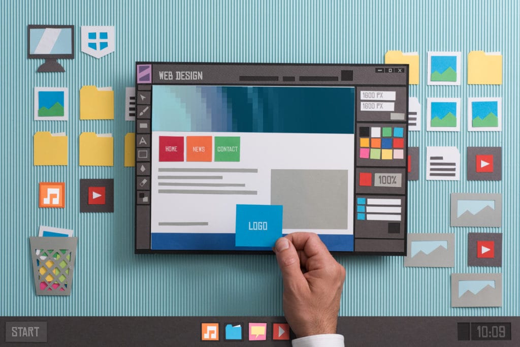Web designer drafting web templates and web page layouts using a professional software, collage and paper cut composition