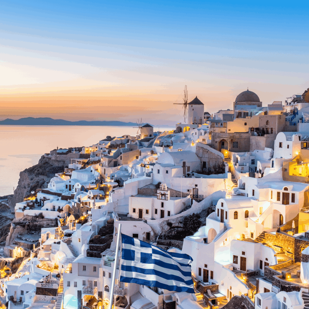 Santorini sunset with white architecture and Aegean Sea view.
