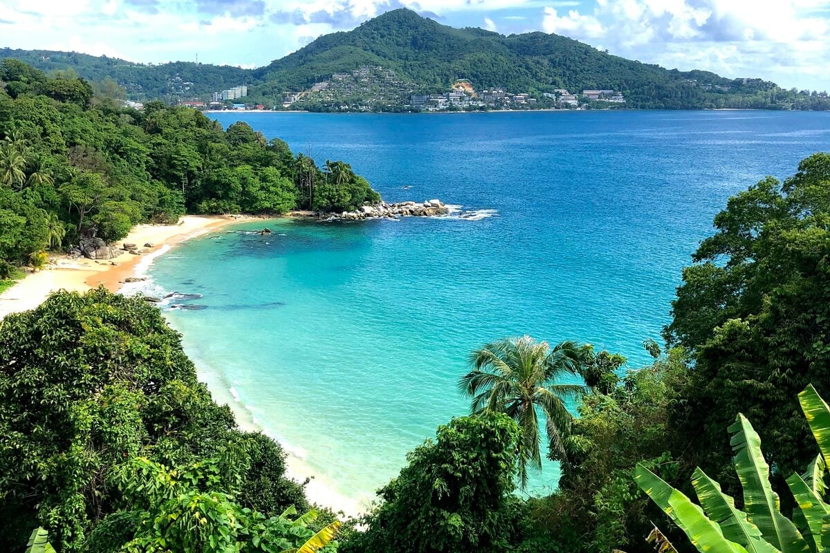 Aerial view of a tropical Thai bay with turquoise water and lush hillside - Thailand retirement lifestyle