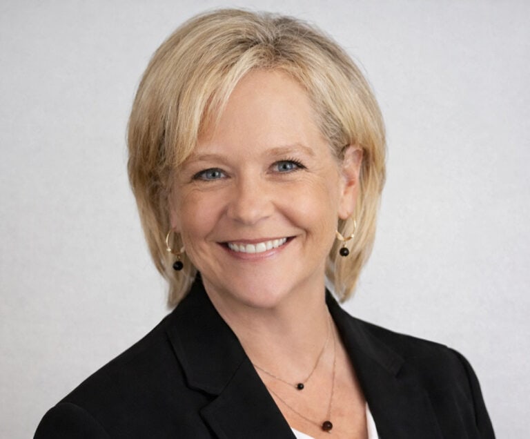 Headshot of Liz Alexander smiling, wearing a black blazer. Expertise in leadership and coaching.