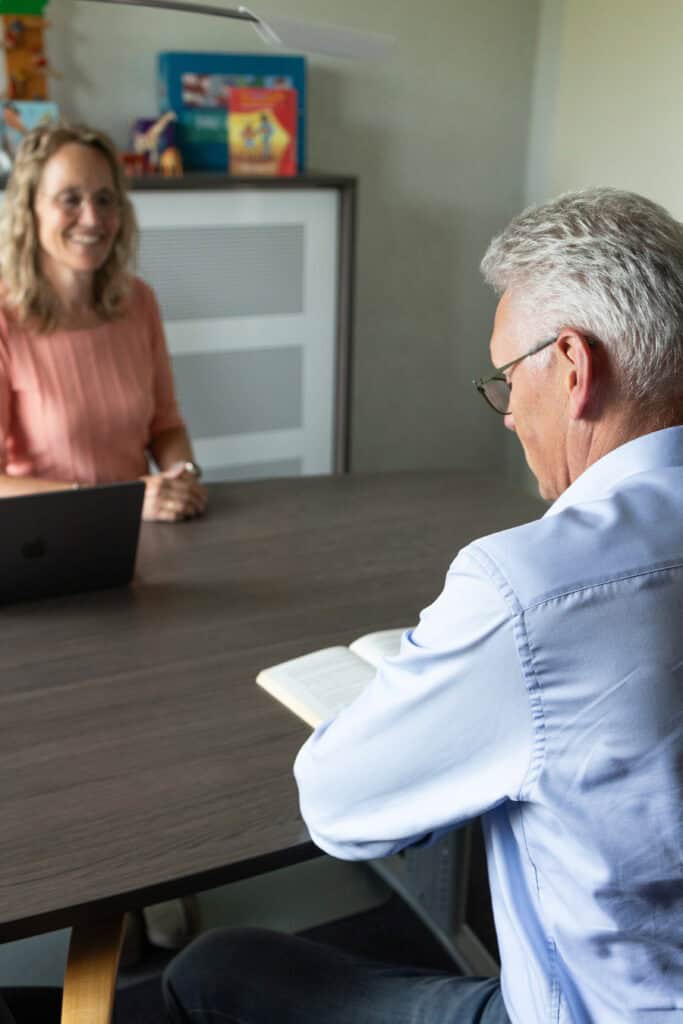 Logopedie voor volwassenen - gesprek aan tafel logopedist en volwassen man