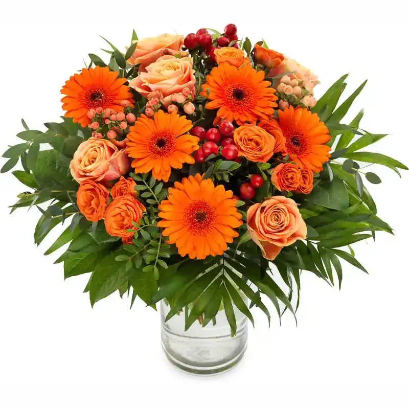 fleur Fleuri orange avec roses et feuillage vert dans un vase en verre.