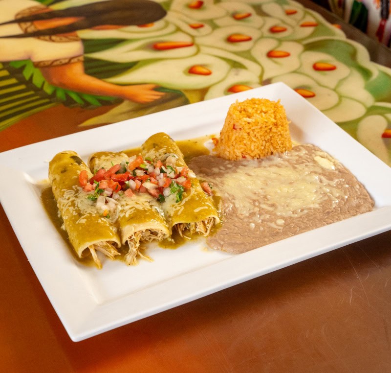 Authentic Mexican cuisine featuring enchiladas, rice, and refried beans.