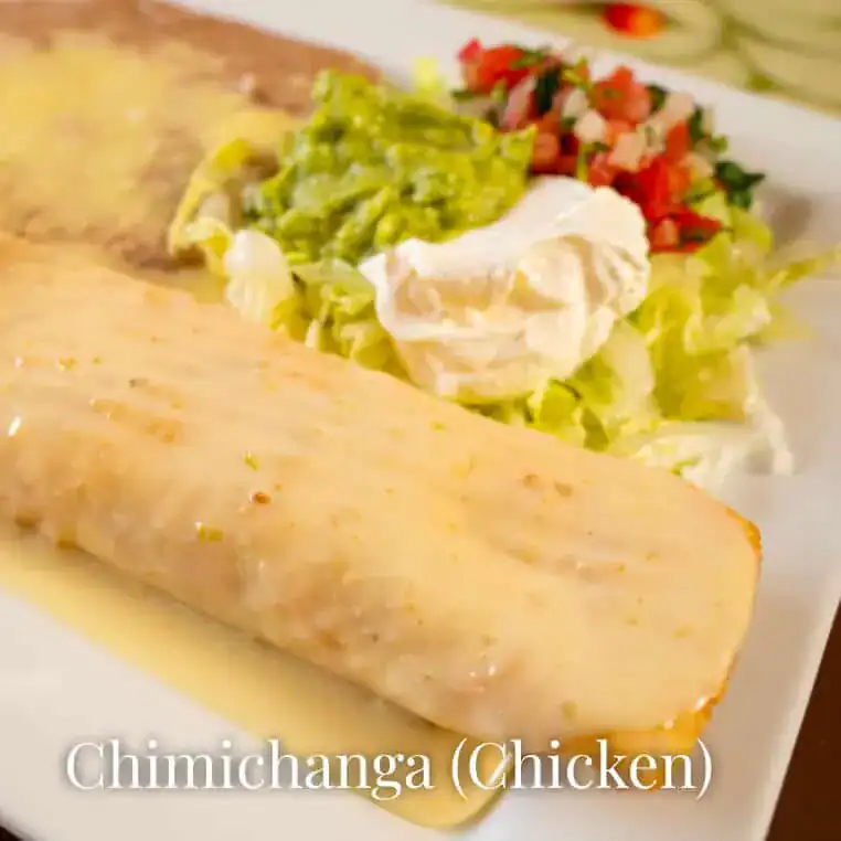 Delicious chimichanga with chicken, served with fresh toppings and creamy sauce.