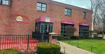 Modern brick building with new website branding signage outside.