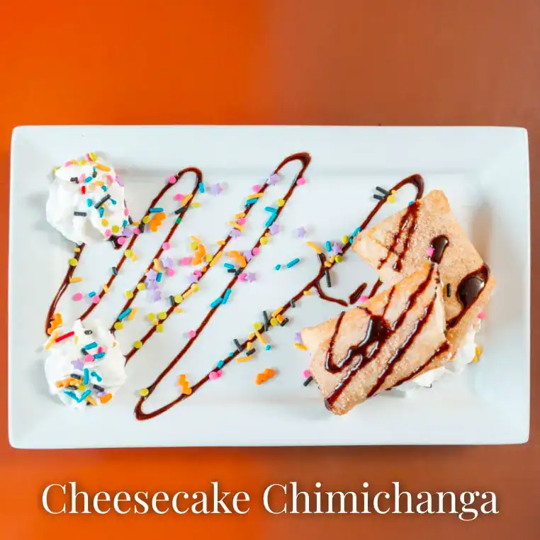 Delicious cheesecake chimichanga topped with chocolate drizzle and colorful sprinkles. Perfect for a.