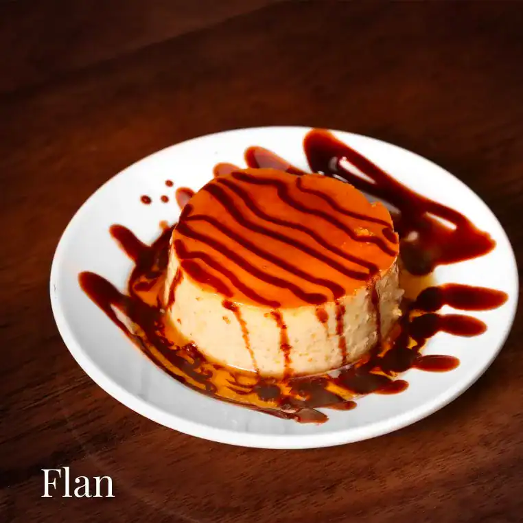 Delicious caramel flan dessert served on a white plate with caramel drizzle.