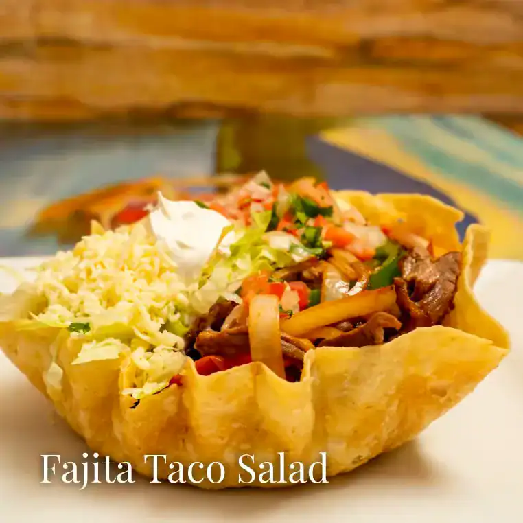 Delicious fajita taco salad with beef, vegetables, and cheese in a crispy shell.