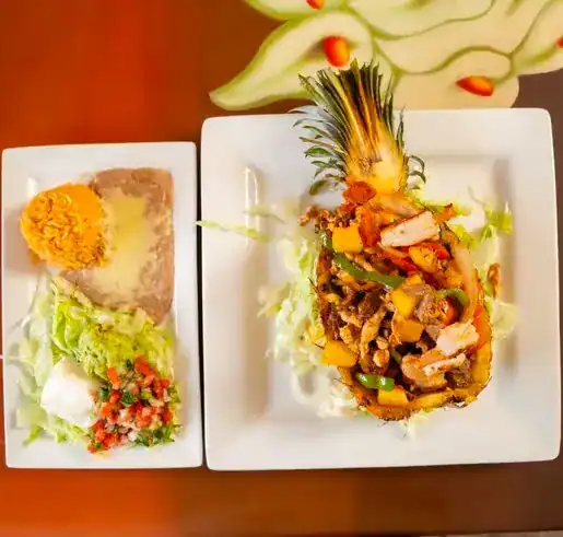Fresh grilled pineapple with vegetable stir-fry on white plates.