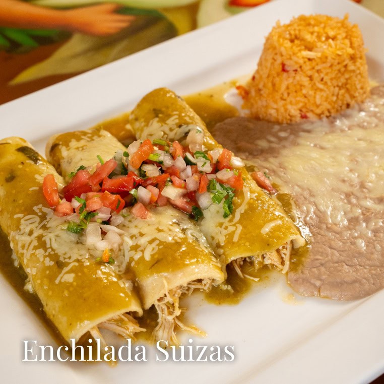Delicious Mexican enchiladas suizas topped with cheese, served with rice and beans on a white plate.