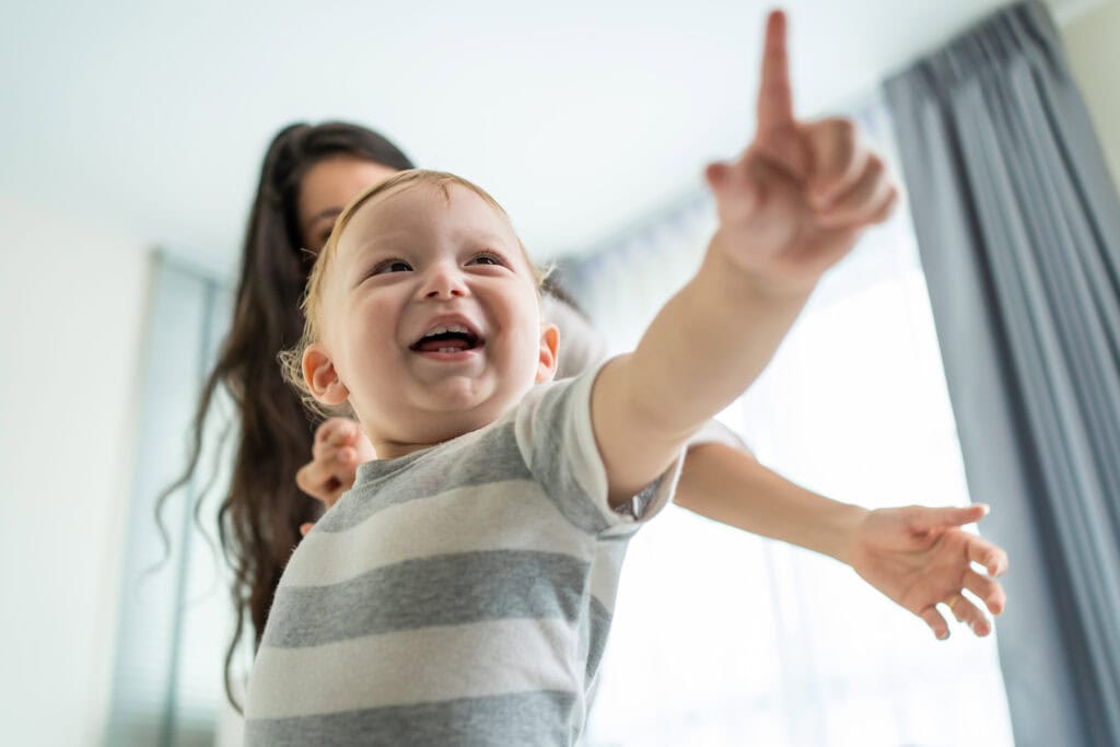 Bebê iniciando sua jornada na comunicação apontando objetos.