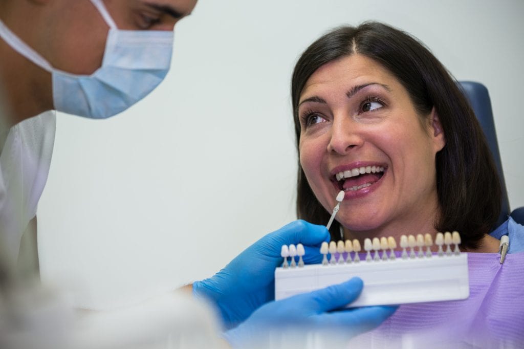 Porcelain dental crowns being tested on a woman at Ludhiana Dental Centre, expert dental care and cosmetic dentistry services.