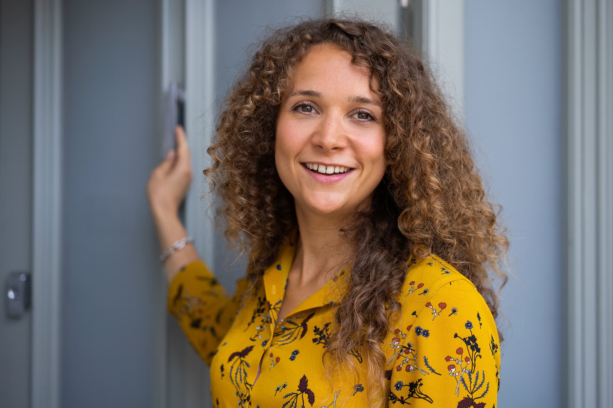 Lorraine Wilkes, a coach, smiles warmly in soft light, a London brand photographer's portrait.