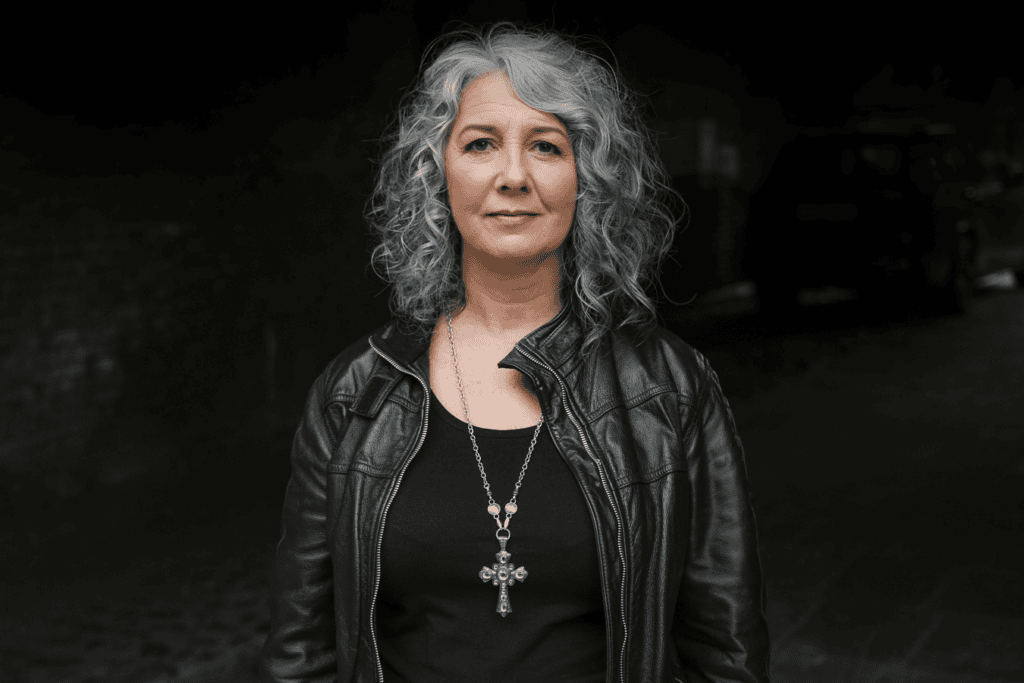 Phil Askew, London brand photographer, captures a confident woman with grey hair and a leather jacket in a striking personal brand portrait.
