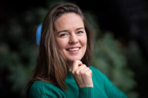 Katrin Mantay, a confident leader, smiles warmly in a natural portrait captured by a London brand photographer.