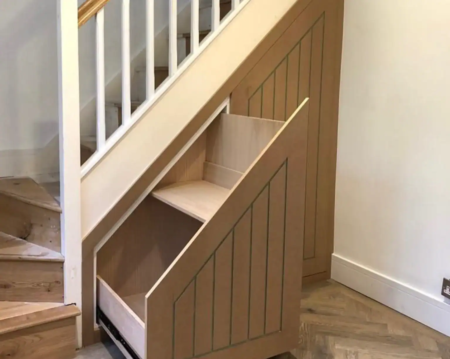 Under stairs storage in panelled wood effect pulled out for show