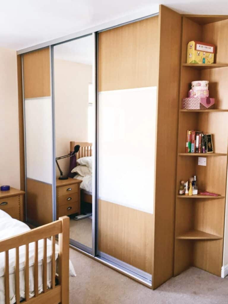 Stylish wooden sliding wardrobe with mirrored doors, custom designed by Made 2 Measure Interiors.