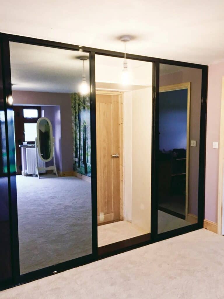 Bespoke sliding wardrobe with full-length mirrors, ideal for custom bedroom storage solutions.