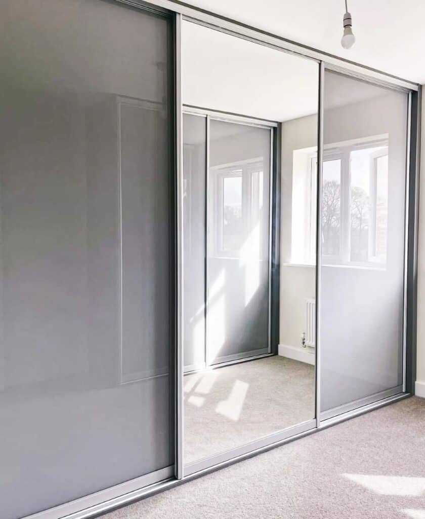 1. Modern grey sliding wardrobe with mirrored doors for custom interior storage solutions.