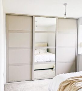 Built-in sliding wardrobe with mirror and modern finish for contemporary bedroom storage solutions.