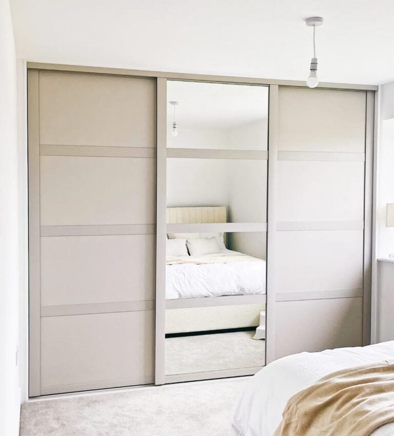 Built-in sliding wardrobe with mirror and modern finish for contemporary bedroom storage solutions.