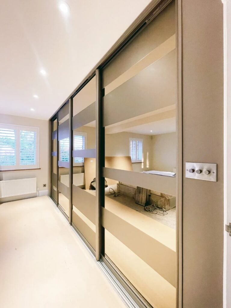 Bespoke sliding wardrobe with mirror doors, custom fitted storage solution for bedroom space.