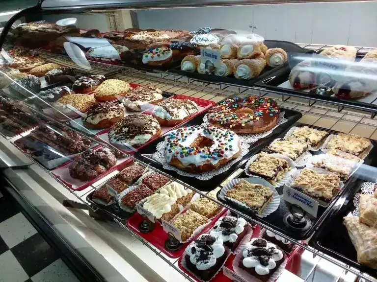 Assorted pastries and cakes arranged in a bakery display case, showcasing a variety of sweet treats.