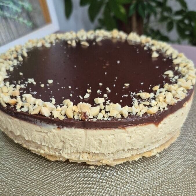 Creamy cheesecake topped with glossy chocolate ganache and chopped nuts. Perfect for dessert lovers.