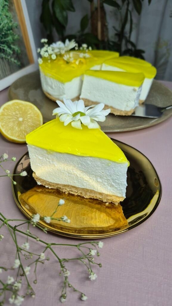 Creamy lemon cheesecake with a graham cracker crust and glossy lemon topping, perfect for desserts.