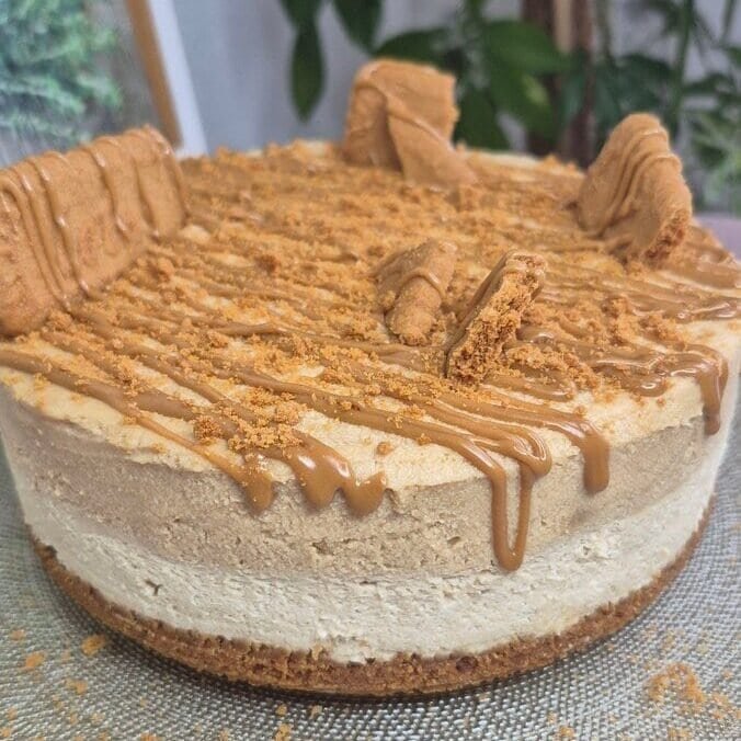 No-bake Lotus Biscoff cake topped with crushed Biscoff biscuits and a Biscoff spread drizzle, shown on a plate.