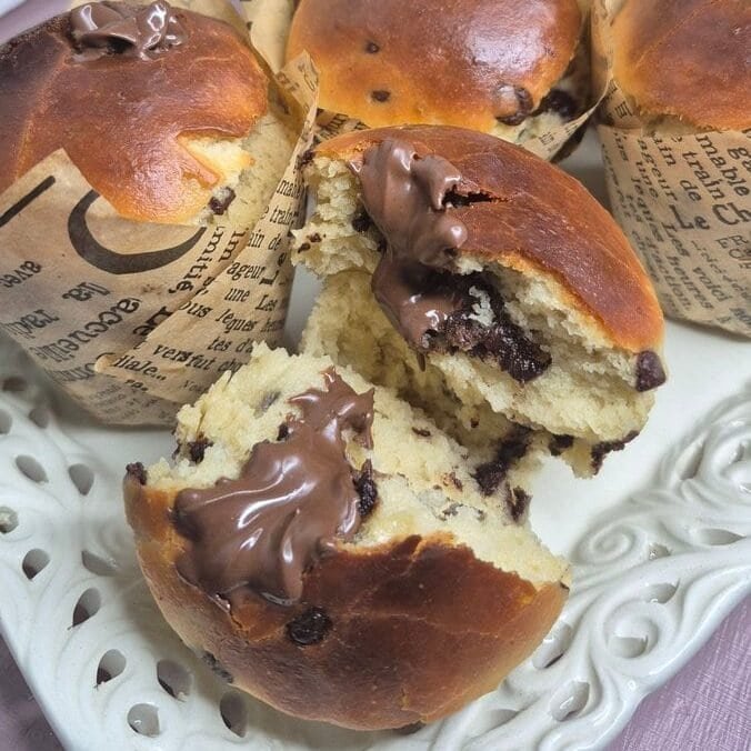 Chocolate chip muffins with one torn open to show the fluffy crumb.