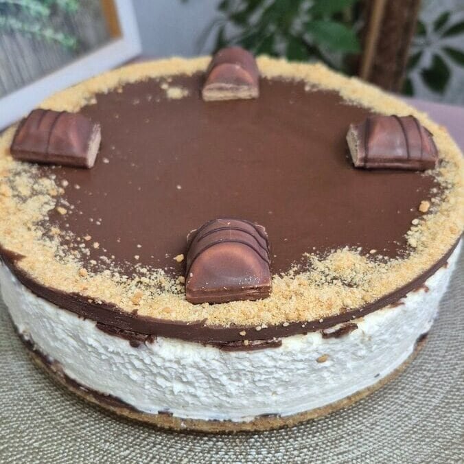 Round Nutella Kinder Bueno no-bake cake with creamy mascarpone layer, crunchy biscuit crust, and smooth Nutella top
